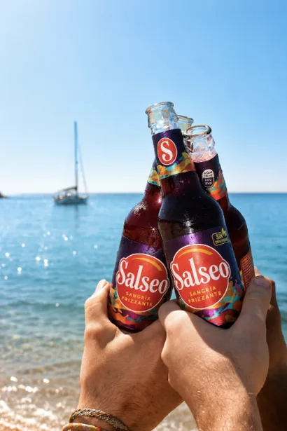 Brindis con botellas de Salseo junto al mar